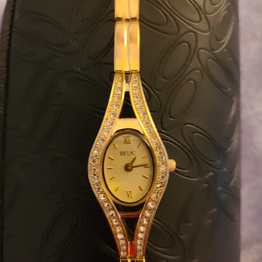 Ladies Relic Gold Watch with crystals on face of band.